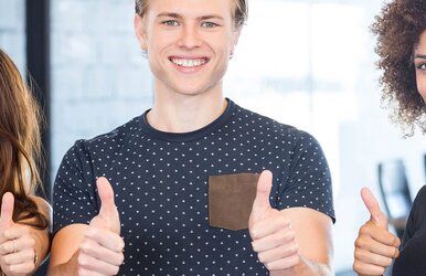 Foto zur Betriebliche Arbeitskraftabsicherung, auf der drei junge Menschen die Daumen anerkennend hoch halten