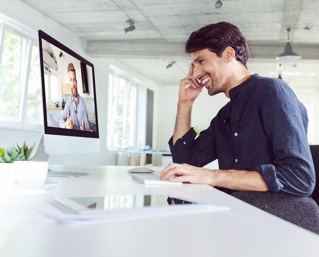 Ein Vermittler, der am Schreibtisch sitzt und am Coaching für Makler zur Lead-Generierung mit Social Media teilnimmt