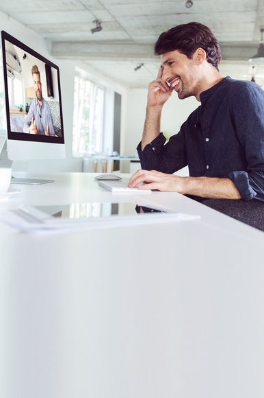 Ein Vermittler, der am Rechner sitzt und am Coaching zur Lead-Gewinnung über Social Media teilnimmt