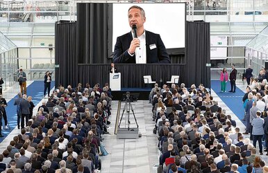 Fonds Finanz Geschäftsführer Norbert Porazik als Speaker vor vollem Saal bei der MMM-Messe 2024 in München