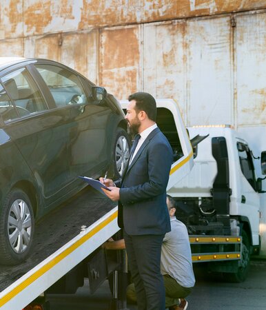 Ein Vermittler von Kfz-Versicherungen vor einem Fahrzeug