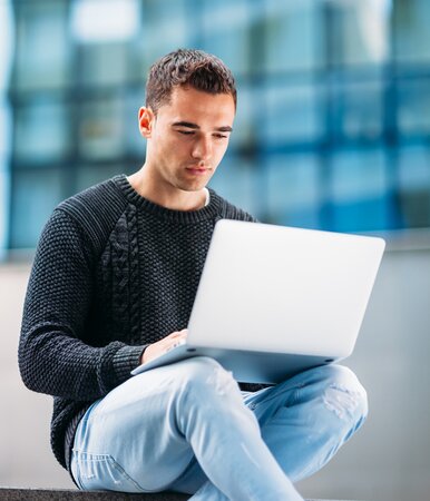 Ein Vermittler von Fonds Finanz Vermögensverwaltungen, der am Laptop arbeitet