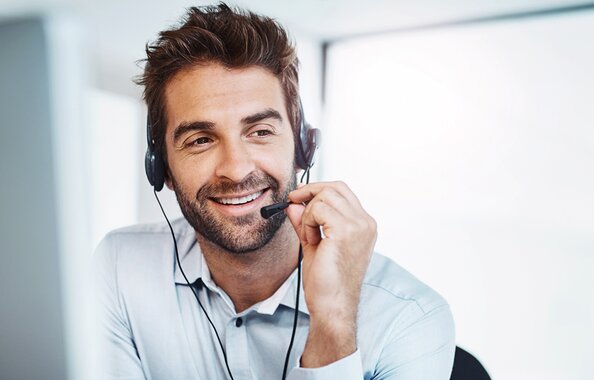 Mitarbeiter der Fonds Finanz, der mit Telefon-Headset Anrufe entgegennimmt