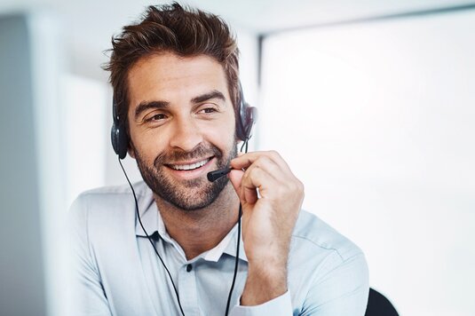 Mitarbeiter der Fonds Finanz, der mit Telefon-Headset Anrufe entgegennimmt