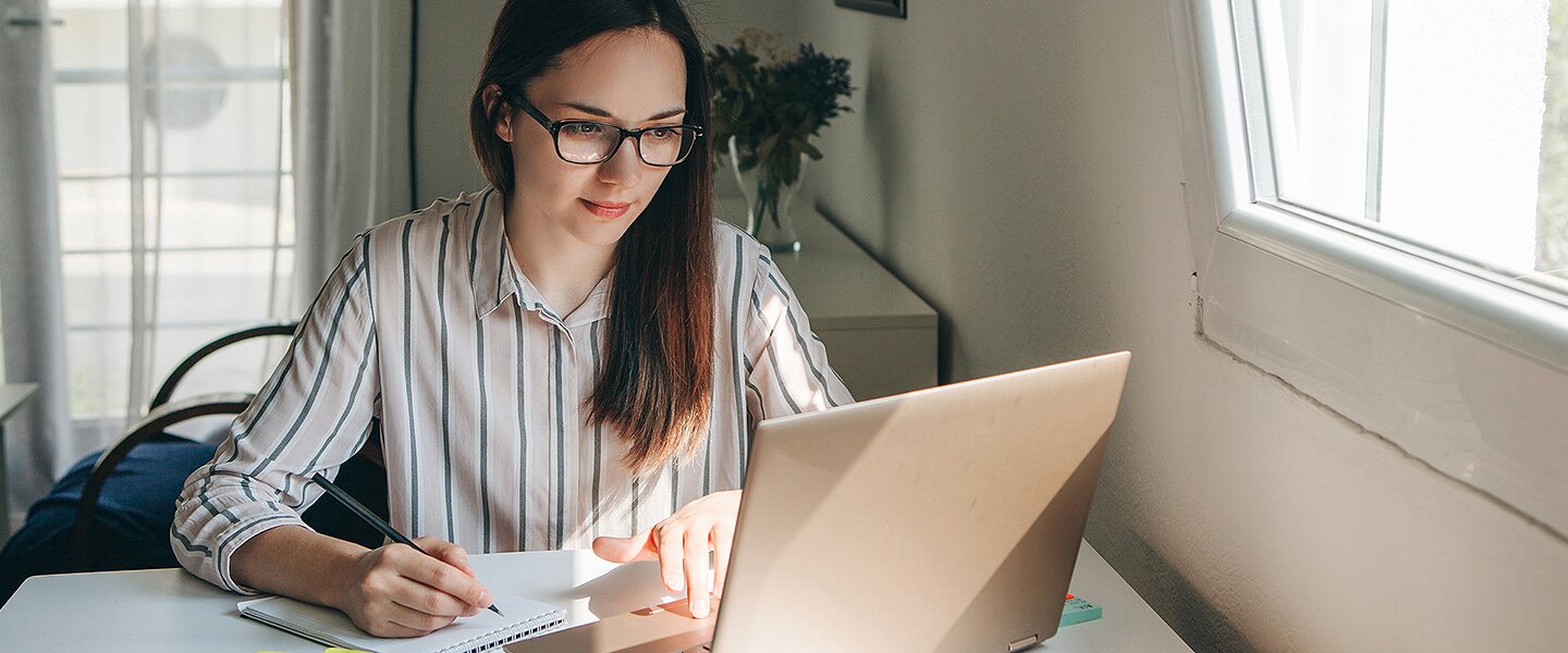 Eine Maklerin, die sich online über aktuelle Themen der Baufinanzierung informiert